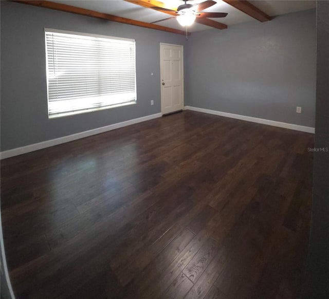 spare room with beamed ceiling, dark hardwood / wood-style flooring, and ceiling fan