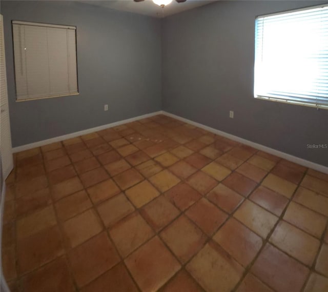 spare room with tile patterned floors and ceiling fan