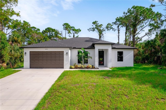 view of front facade with a garage, concrete driveway, a front yard, and stucco siding