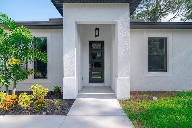 view of exterior entry with stucco siding