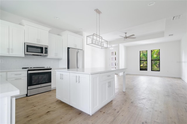 kitchen with ceiling fan, stainless steel appliances, light hardwood / wood-style floors, and white cabinetry