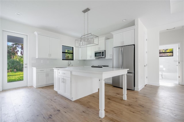 kitchen featuring a center island, light wood-type flooring, appliances with stainless steel finishes, and white cabinets