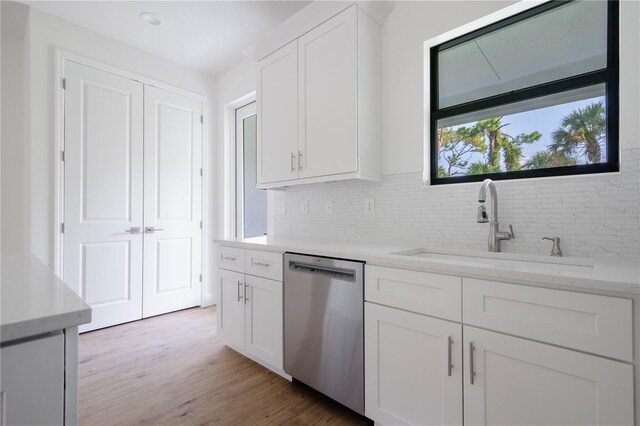 kitchen featuring dishwasher, white cabinetry, light hardwood / wood-style floors, and tasteful backsplash