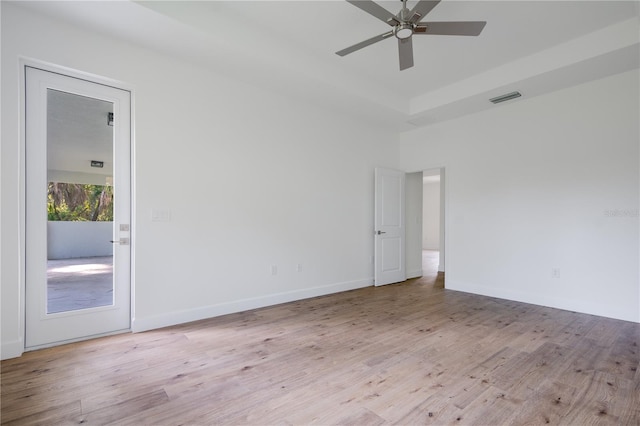 spare room featuring a high ceiling, ceiling fan, and light hardwood / wood-style floors