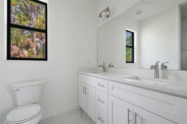 bathroom featuring tile patterned flooring, toilet, and vanity