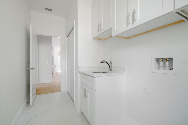 clothes washing area featuring marble finish floor, hookup for a washing machine, visible vents, cabinet space, and a sink