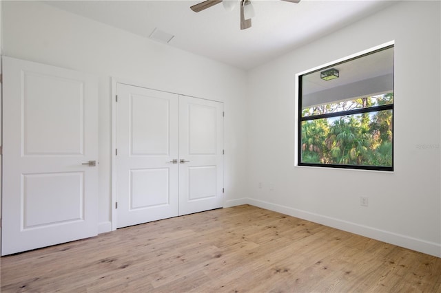 unfurnished bedroom with ceiling fan, a closet, and light hardwood / wood-style floors