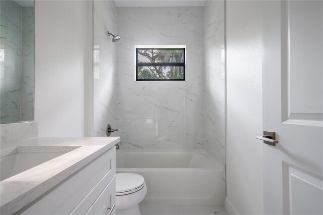 full bathroom with tile patterned flooring, toilet, tiled shower / bath combo, and vanity