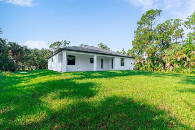 rear view of property featuring a lawn