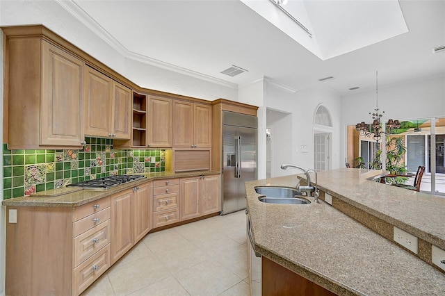 kitchen featuring stainless steel appliances, sink, light tile patterned floors, and a skylight