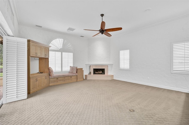 unfurnished living room featuring a fireplace, light colored carpet, a wealth of natural light, and ceiling fan