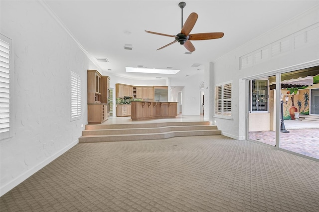 interior space with light carpet, crown molding, and ceiling fan