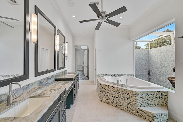 bathroom with tile patterned flooring, vanity, ceiling fan, tiled tub, and ornamental molding