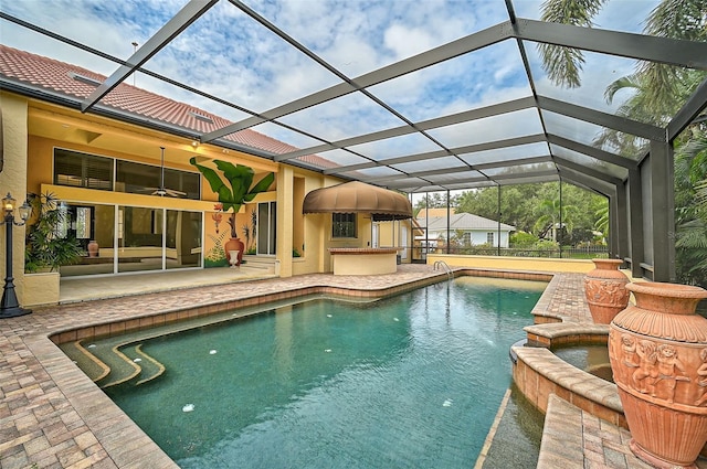 view of pool with ceiling fan, a patio area, and glass enclosure