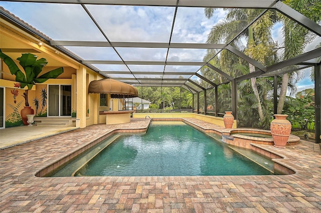 view of swimming pool with glass enclosure, a patio, and an in ground hot tub