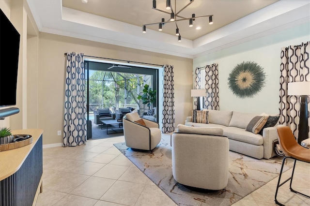 living room featuring a tray ceiling, an inviting chandelier, rail lighting, and light tile patterned floors