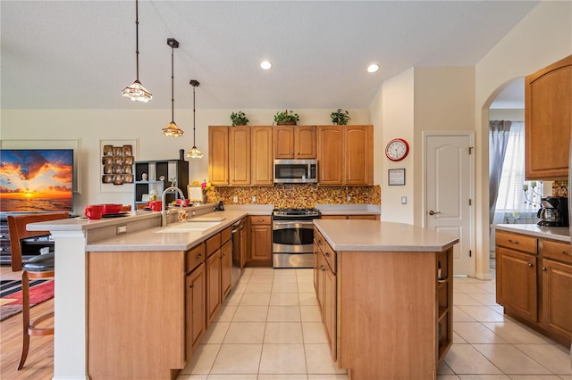 kitchen featuring pendant lighting, sink, light tile patterned flooring, and stainless steel appliances