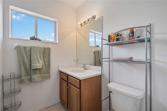 bathroom featuring tile patterned flooring, plenty of natural light, vanity, and toilet