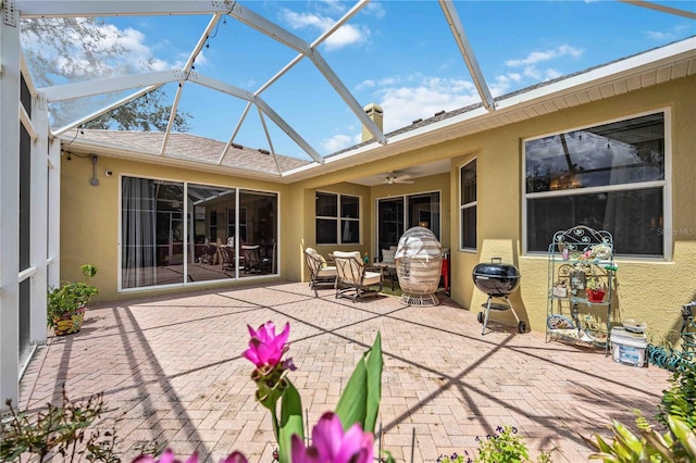 view of patio featuring ceiling fan and a lanai