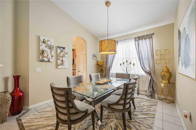 dining space with light tile patterned flooring and vaulted ceiling