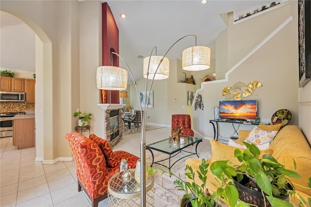 living room featuring a stone fireplace and light tile patterned flooring