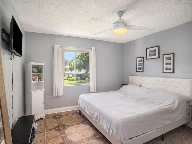 bedroom with a textured ceiling and ceiling fan