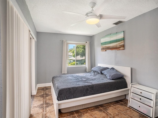 bedroom featuring a closet, ceiling fan, and a textured ceiling