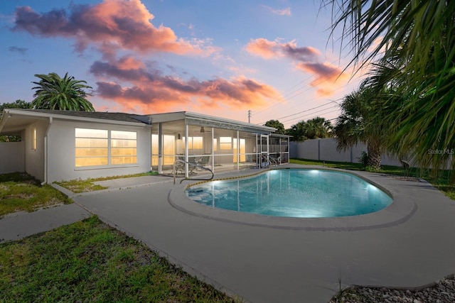 pool at dusk featuring a sunroom, a fenced backyard, a fenced in pool, and a patio