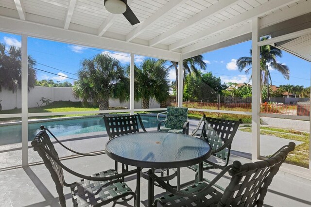 sunroom / solarium with ceiling fan and beamed ceiling