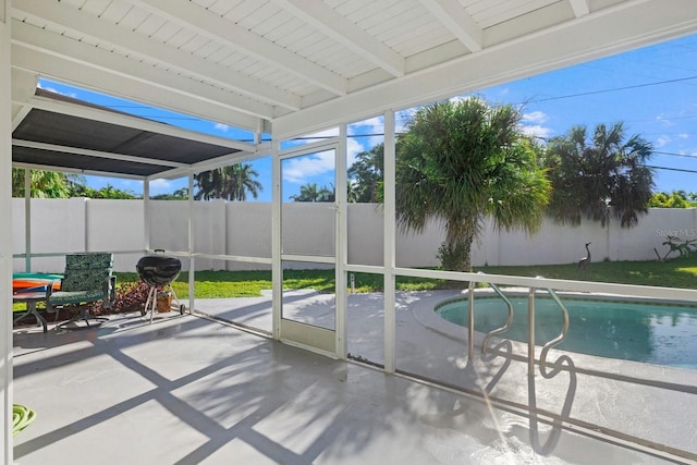 unfurnished sunroom featuring beam ceiling