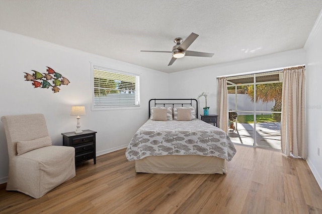 bedroom featuring ceiling fan, light hardwood / wood-style floors, access to outside, and a textured ceiling