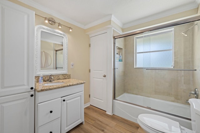 full bathroom with shower / bath combination with glass door, vanity, wood-type flooring, toilet, and ornamental molding