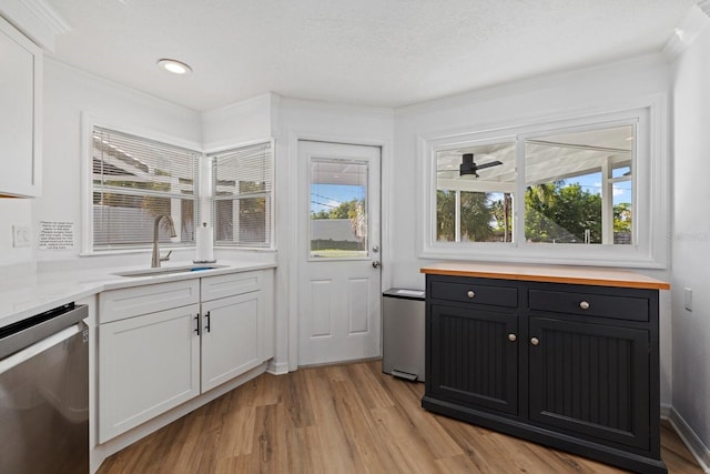 kitchen with light wood-type flooring, white cabinetry, dishwasher, and a sink