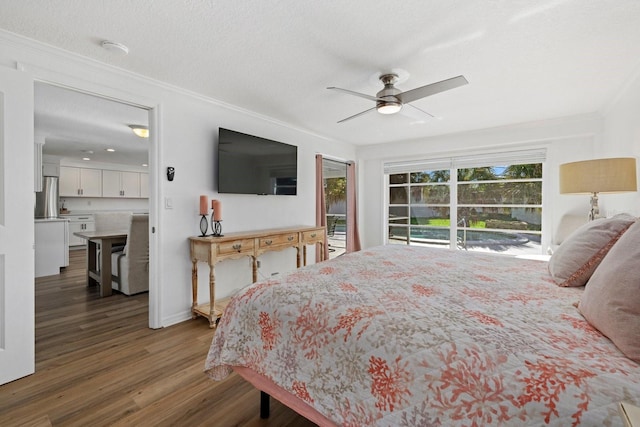 bedroom featuring crown molding, stainless steel refrigerator, dark wood-type flooring, ceiling fan, and a textured ceiling