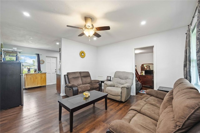 living room featuring ceiling fan and dark hardwood / wood-style flooring