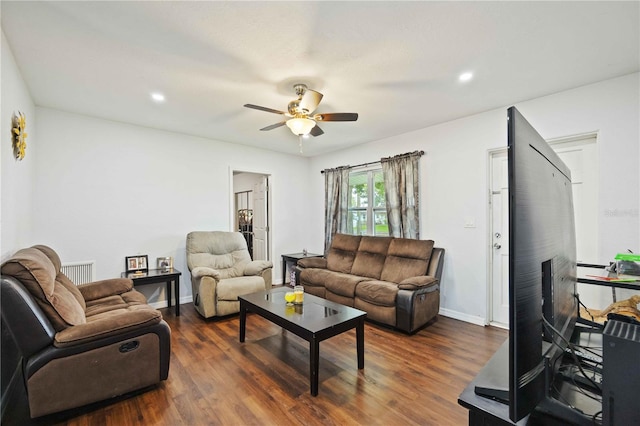 living room featuring dark wood-type flooring and ceiling fan