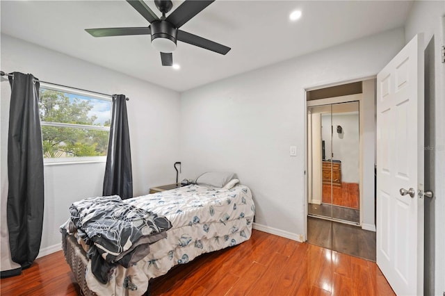 bedroom featuring hardwood / wood-style flooring, ceiling fan, and a closet