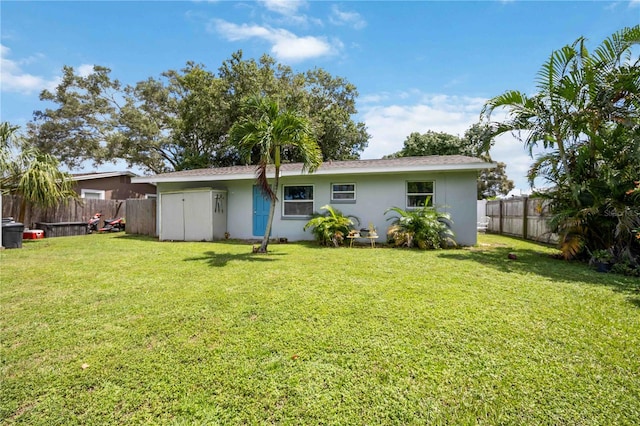 rear view of property featuring a lawn