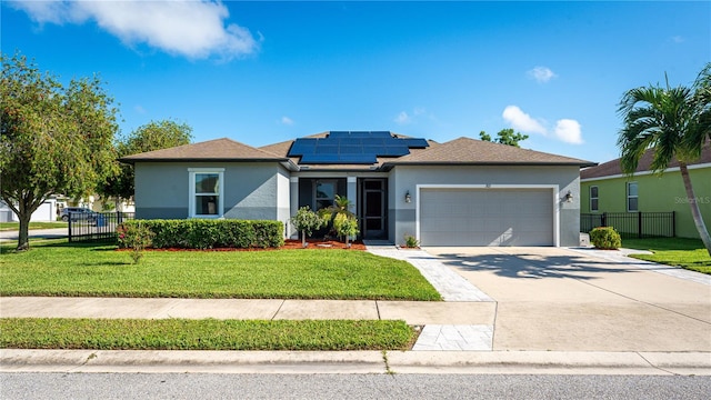 view of front of property with a garage, solar panels, and a front yard