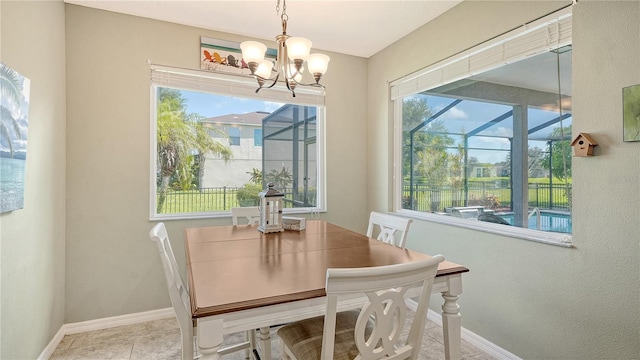 dining area featuring a healthy amount of sunlight, light tile patterned floors, and a chandelier