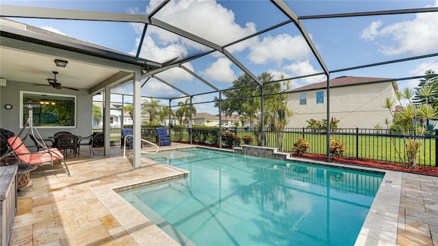 view of pool with a lanai, a patio area, ceiling fan, and pool water feature