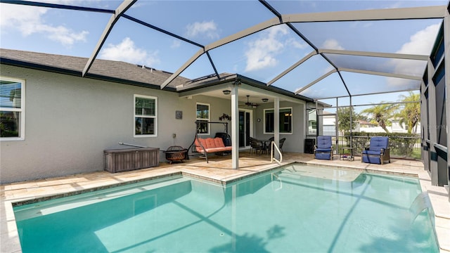 view of pool with ceiling fan, a patio area, and glass enclosure