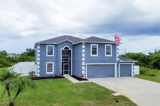 view of front of home featuring an attached garage, fence, driveway, stucco siding, and a front yard