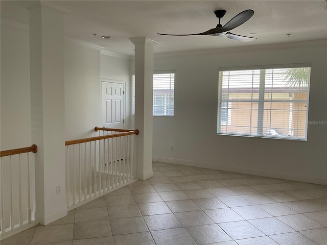 unfurnished room featuring ornamental molding, light tile patterned flooring, ceiling fan, and decorative columns