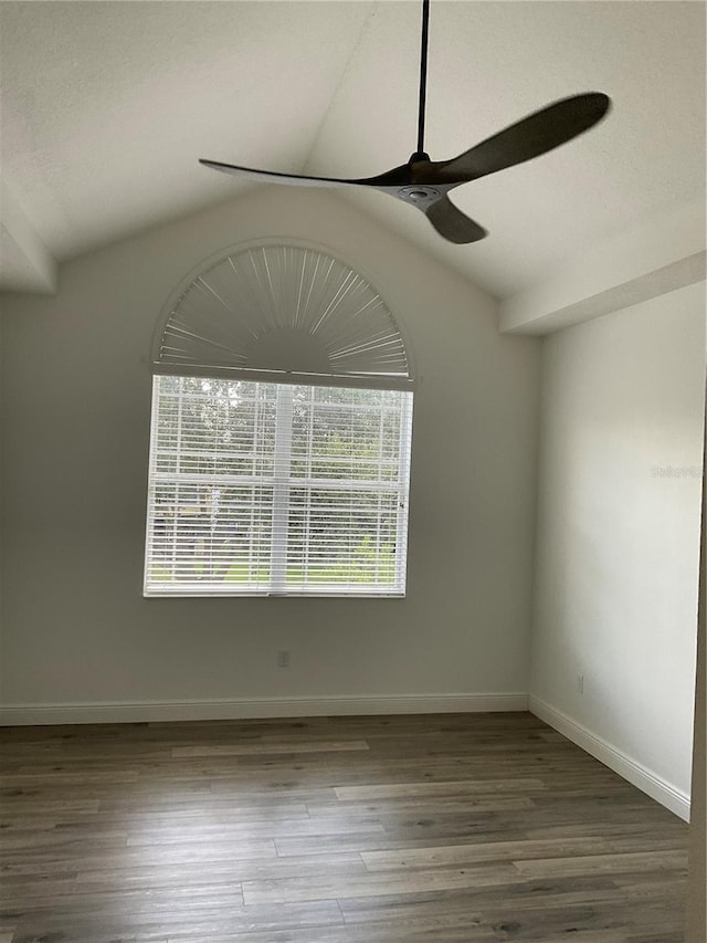 unfurnished room with ceiling fan, baseboards, vaulted ceiling, and wood finished floors