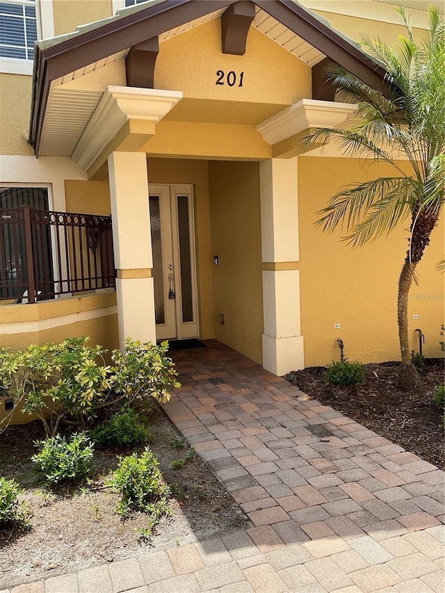 entrance to property featuring stucco siding