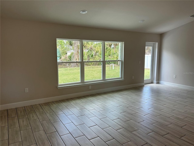 spare room with visible vents, baseboards, and wood finished floors