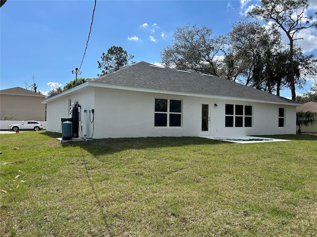 back of property featuring a patio area and a lawn