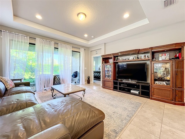 tiled living room featuring a raised ceiling