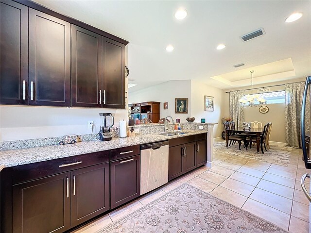 kitchen featuring dishwasher, decorative light fixtures, light stone countertops, sink, and a raised ceiling